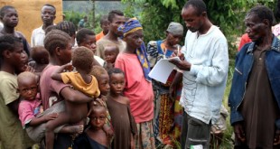 Carnet à mains, un préposé du HCR entrain d’enregistré une famille de pygmées dans un centre des déplacés de Dongo(RDC) à Betou(RCA) le 18/11/2009. Ph. Don John Bompengo